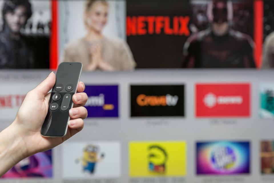 Montreal, &ETH;¡anada - January 3, 2016: Human hand holding The 4th generation Apple TV new Siri remote browsing the channel selections. The Apple TV is produced by Apple Inc.