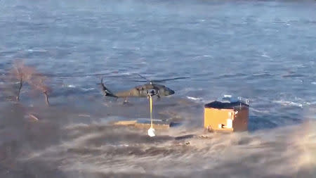 A Nebraskan National Guard helicopter drops sandbags to protect water wells in Lincoln, Nebraska, U.S. March 16, 2019. Office of Governor Pete Ricketts/Handout via REUTERS