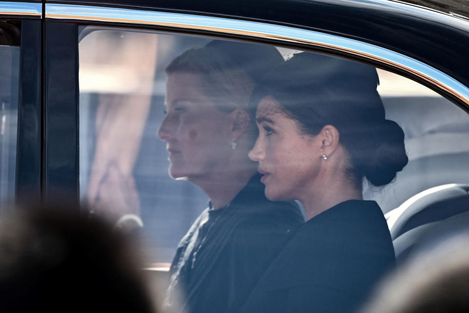 Britain's Sophie, Countess of Wessex (L) and Meghan, Duchess of Sussex are driven behind the coffin of Queen Elizabeth II, adorned with a Royal Standard and the Imperial State Crown and pulled by a Gun Carriage of The King's Troop Royal Horse Artillery, during a procession from Buckingham Palace to the Palace of Westminster, in London on September 14, 2022.<span class="copyright">Marco Bertorello—AFP/Getty Images</span>