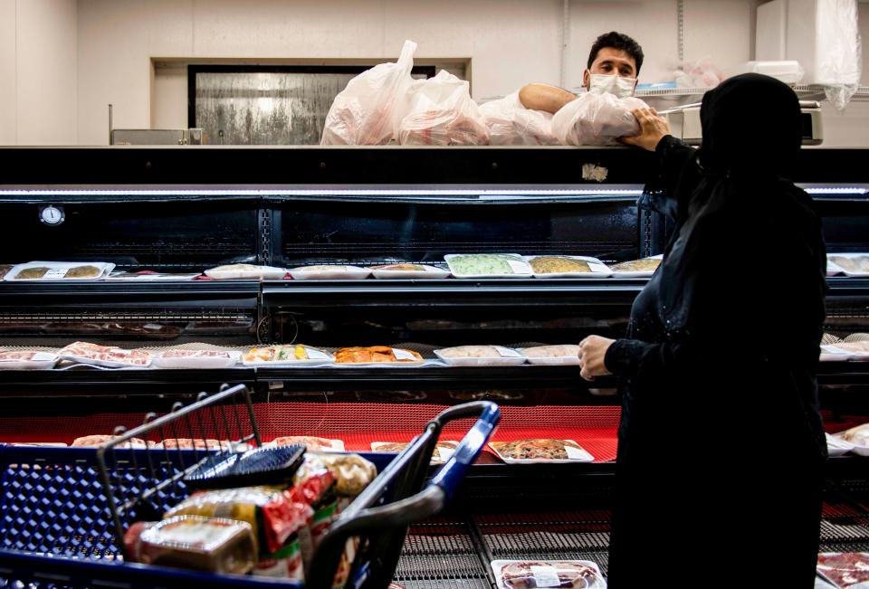 Naim Nazari passes meat to a customer at Alrahmah Mediterranean Grocery in Cordova on Tuesday, Sept. 1, 2020. The Eldahan family has owned the business for 12 years and has served their community in Memphis despite the pandemic and have provided them with essential products.