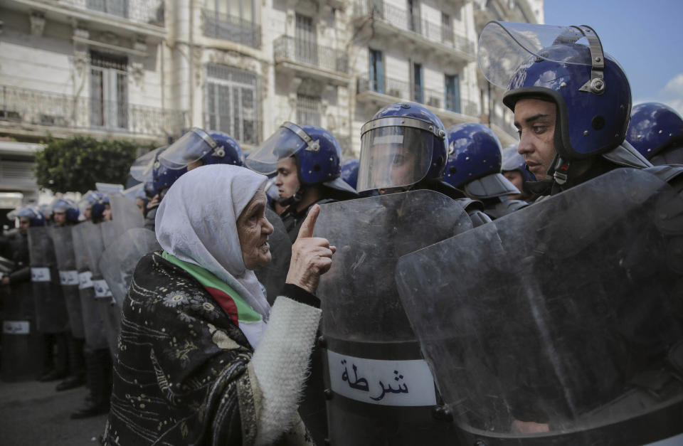 FILE - In this April 10, 2019 file photo, a woman confronts security forces during a demonstration in Algiers, Algeria. While the 2011 Arab Spring uprisings that took place in Egypt, Tunisia, Libya and Syria were directed at long-ruling autocrats, the current economically driven uprisings in Lebanon, and Iraq are directed at corrupt political elites who have failed at providing their people with basic services. Jordan, Algeria and Sudan are all witnessing similar protests. (AP Photo/Mosa'ab Elshamy, File)