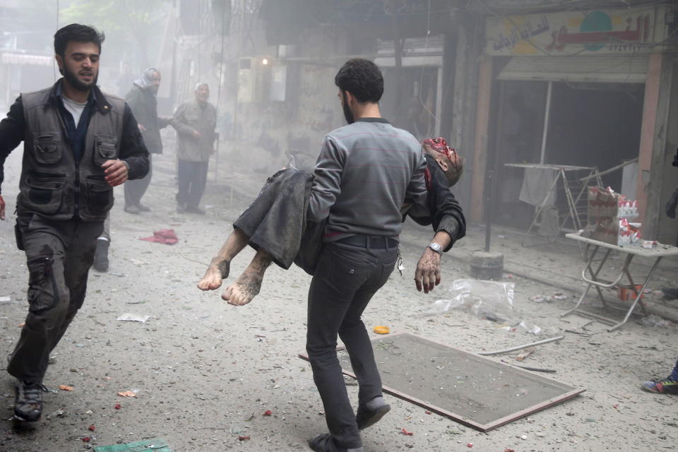 resident carries an injured man through a site damaged from what activists said was an airstrike by forces loyal to Syria's President Bashar al-Assad on the main field hospital in the town of Douma, eastern Ghouta in Damascus October 29, 2015.