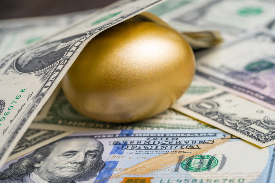 A gold egg surrounded by money.