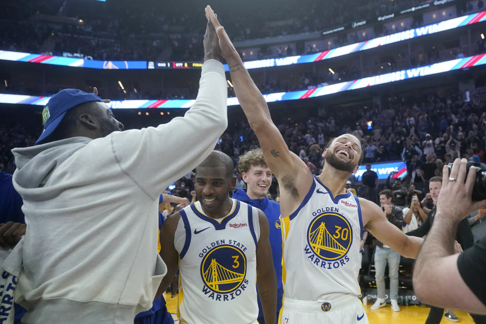 Golden State Warriors guard Stephen Curry (30) celebrates with guard Chris Paul (3) and Draymond Green, left, after the Warriors defeated the Sacramento Kings in an NBA preseason basketball game in San Francisco, Wednesday, Oct. 18, 2023. (AP Photo/Jeff Chiu)