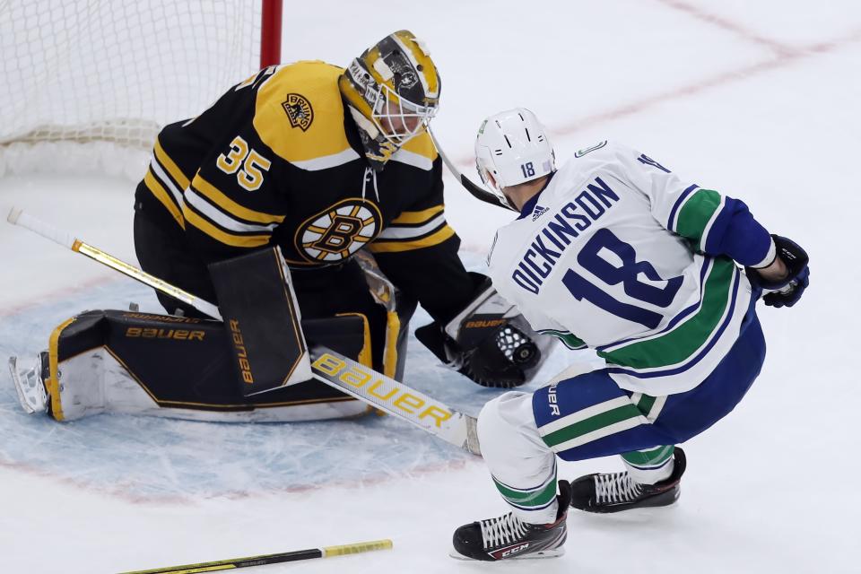 Boston Bruins' Linus Ullmark (35) blocks a shot by Vancouver Canucks' Jason Dickinson (18) during the first period of an NHL hockey game, Sunday, Nov. 28, 2021, in Boston. (AP Photo/Michael Dwyer)