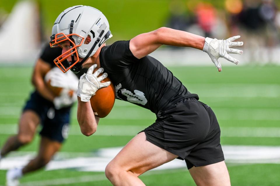 Charlotte's Cutler Brandt runs after a catch during a MHSAA/MHSFCA spring football evaluation camp on Tuesday, May 16, 2023, at DeWitt High School.