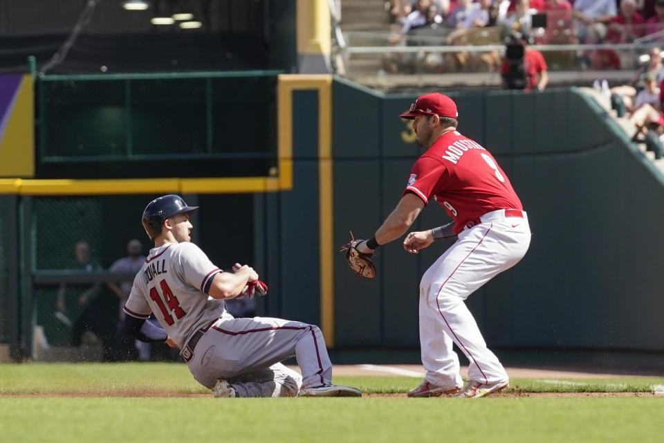 Cincinnati Reds first baseman Mike Moustakas, right, tags out Atlanta Braves' Adam Duvall (14) at first base during the second inning of a baseball game Saturday, July 2, 2022, in Cincinnati. (AP Photo/Jeff Dean)