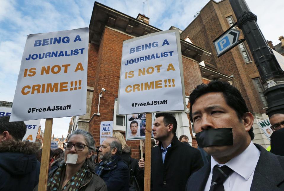 Journalists hold up placards as they demonstrate across the street from Egypt's embassy in central London, Wednesday, Feb. 19, 2014. The protest organized by the National Union of Journalists called for the protection of journalists in Egypt, where six have been killed and many more injured covering events on the streets of Cairo and the rest of the country. Others, including Al-Jazeera English acting bureau chief in Cairo Mohammed Fahmy, a Canadian-Egyptian, award-winning correspondent Peter Greste of Australia and producer Baher Mohamed, an Egyptian have been imprisoned. (AP Photo/Lefteris Pitarakis)