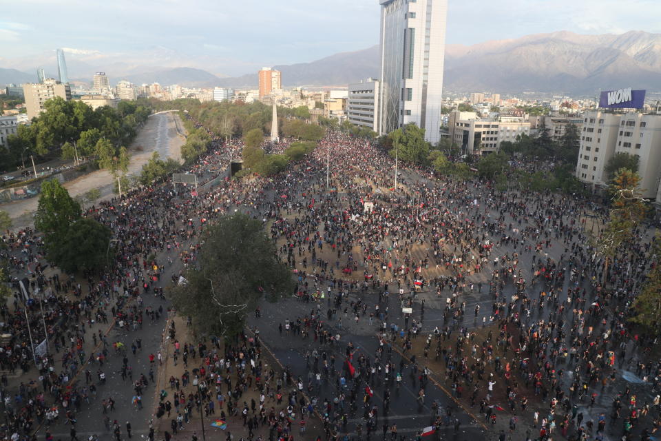 People gather for an anti-government protest in Santiago, Chile Friday, Nov. 1, 2019. Groups of Chileans continued to demonstrate as government and opposition leaders debate the response to nearly two weeks of protests that have paralyzed much of the capital and forced the cancellation of two major international summits. (AP Photo/Esteban Felix)