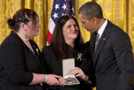 President Barack Obama presents a 2012 Citizens Medal to the family of slain Sandy Hook Elementary School teacher's aide Rachel Davino, Friday, Feb. 15, 2013, in the East Room of the White House in Washington. (AP Photo/Jacquelyn Martin)