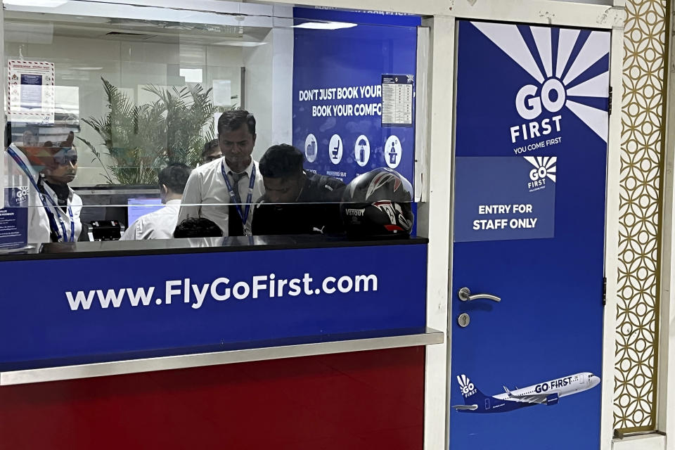 Go First staff work at the airline ticket counter at Indra Gandhi International Airport in New Delhi, India, Wednesday, May 3, 2023. Thousands of travelers have been stranded after no-frills Indian air carrier Go First filed for bankruptcy and suspended its flights for three days, starting Wednesday. (AP Photo/Piyush Nagpal)