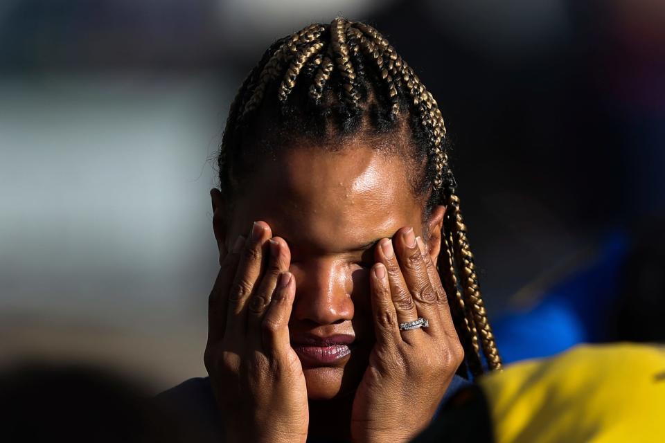 A person waits outside the scene as police investigate after a shooting at a supermarket on Saturday, May 14, 2022, in Buffalo, N.Y.