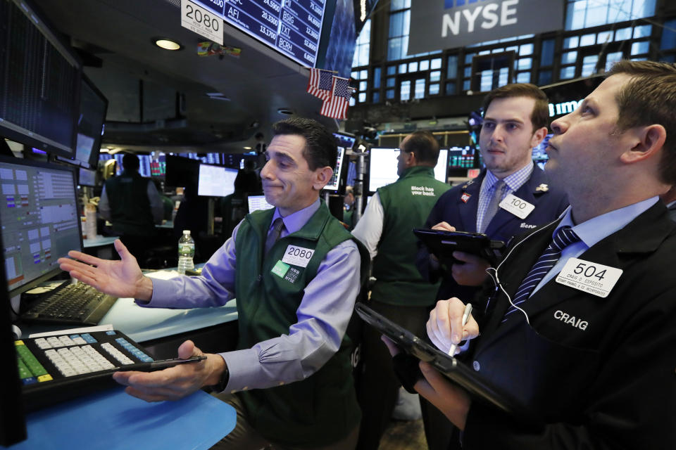 Specialist Peter Mazza, left, work with traders at his post on the floor of the New York Stock Exchange, Tuesday, Jan. 29, 2019. Stocks are opening slightly higher on Wall Street as several big U.S. companies reported solid results for the latest quarter. (AP Photo/Richard Drew)