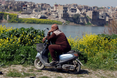 An Iraqi man sits on a scooter by the Tigris River in Mosul, Iraq March 23, 2019. REUTERS/Khalid al-Mousily