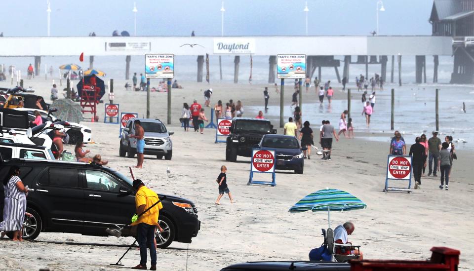 Families and young adults play on the beach near the pier on March 23, 2021, in Daytona Beach, Fla.