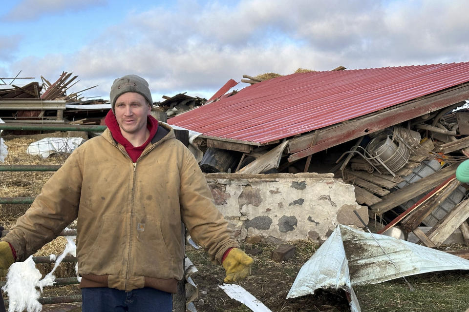 Matt Artis, 34, surveys the wreckage Friday morning, Feb. 9, 2024, after a tornado struck his farm in the Town of Porter, Wis., on Thursday evening. A line of storms and tornadoes fueld by unusually warm February weather tore across southeastern Wisconsin on Thursday. (AP Photo/Todd Richmond)