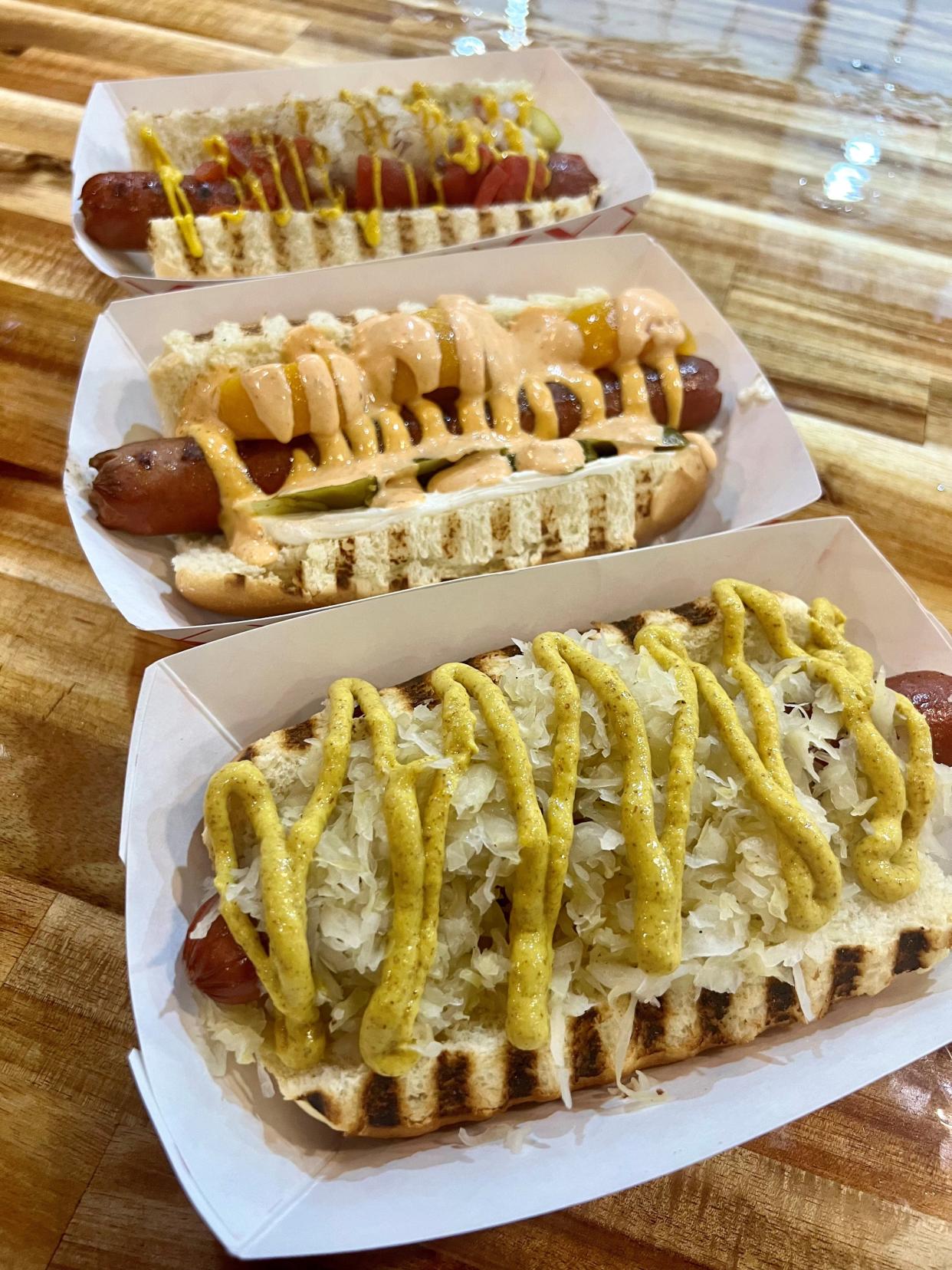 Hot dogs from Daddy's Dogs at the soft opening of its location in The Factory at Franklin on April 18, 2024. From front to back, the New York, Georgia (with chunks of peaches and cream cheese) and the Chicago dog