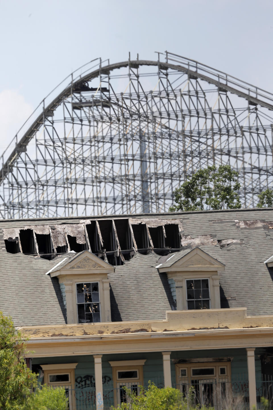 In this June 19, 2019 photo, the roller coaster and concession buildings of the abandoned Six Flags Great Adventure Amusement Park are seen in New Orleans. The abandoned New Orleans amusement park that has stood empty since Hurricane Katrina in 2005 may finally be torn down. The Six Flags park never reopened after the levees failed and flooded the city with water. Mayor LaToya Cantrell says her office is targeting the site for demolition. (AP Photo/Gerald Herbert)