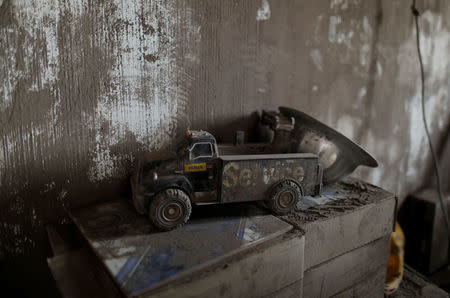 A toy covered with ash lies inside a house affected by the eruption of the Fuego volcano at San Miguel Los Lotes in Escuintla, Guatemala, June 7, 2018. REUTERS/Carlos Jasso