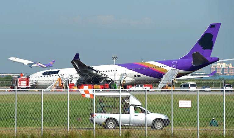 A Thai Airways plane has its logo and name covered up after it skidded off the runway at Suvarnabhumi International Airport in Bangkok on September 9, 2013. The plane skidded after the landing gear malfunctioned, slightly injuring more than a dozen passengers as they evacuated the jet, the airline said