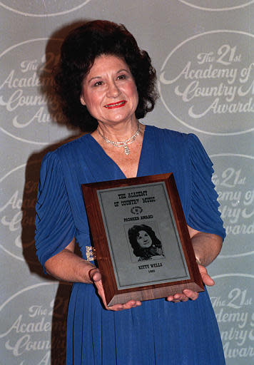 Country singer Kitty Wells poses with the Pioneer Award, presented to her at the annual Academy of Country Music Awards on April 14, 1986. (AP Photo)