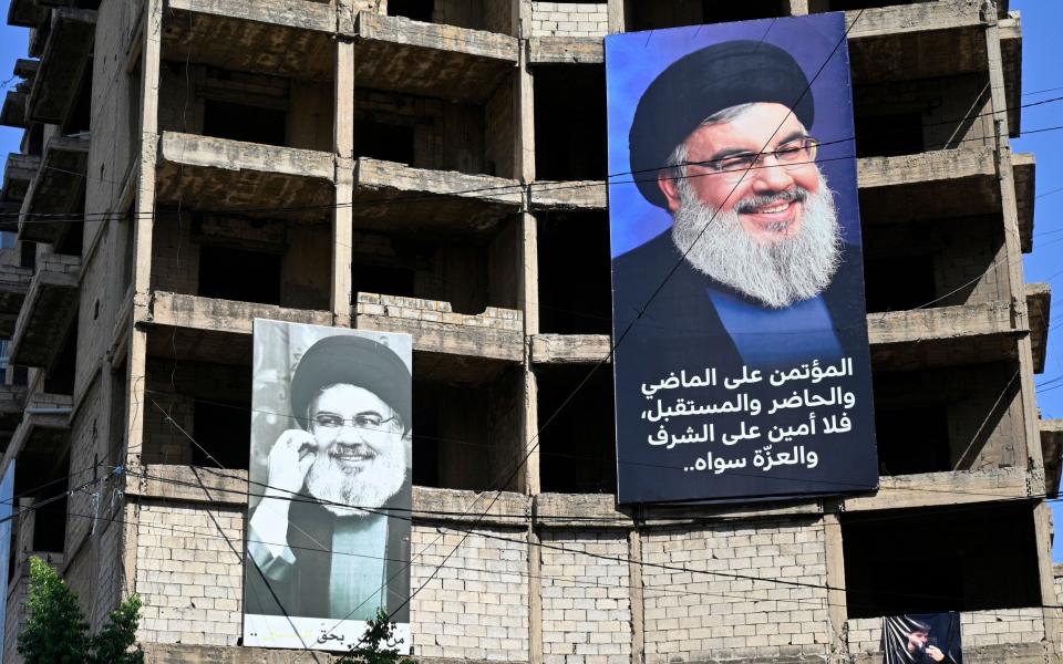 Portraits of Hezbollah leader Hassan Nasrallah are hung on a building in the southern suburbs of Beirut, one day after the announcement of his death