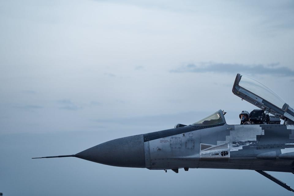 A Ukrainian Tactical Aviation pilot poses in the cockpit of his MIG-29 fighter jet