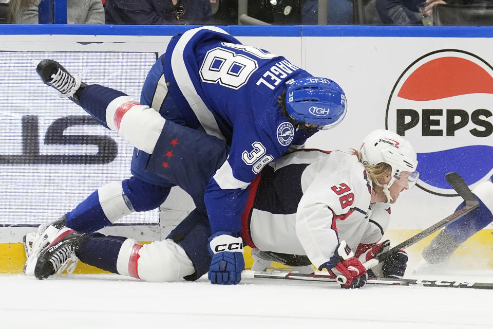 Tampa Bay Lightning left wing Brandon Hagel (top) takes down Washington Capitals defenseman Rasmus Sandin (38) during the first period of an NHL hockey game Thursday, Feb. 22, 2024, in Tampa, Fla. (AP Photo/Chris O'Meara)