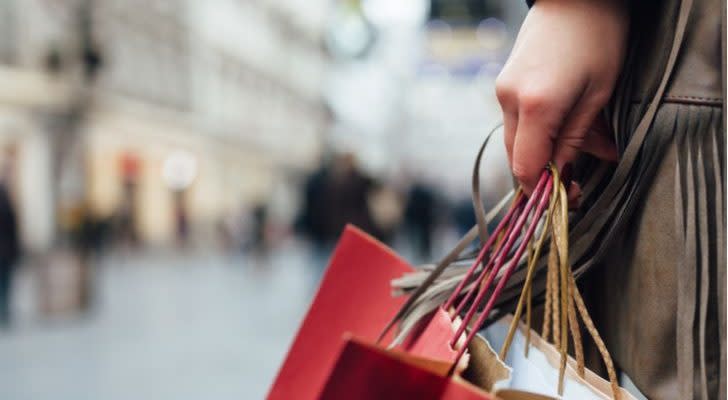 a woman in a mall holding several shopping bags