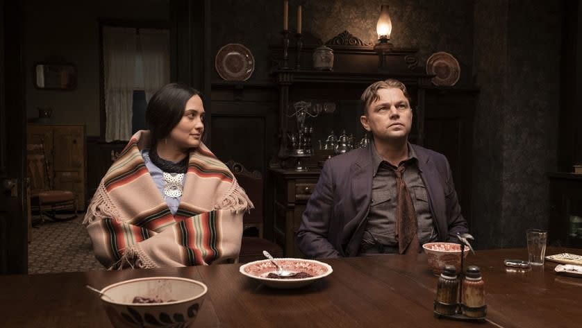 a man and woman sitting at a table with food