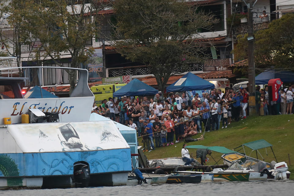 <p>Onlookers watch rescue efforts after the tourist boat Almirante sank in the Reservoir of Penol in Guatape municipality in Antioquia on June 25, 2017. (Joaquin Sarmiento/AFP/Getty Images) </p>