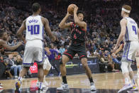 Toronto Raptors forward Scottie Barnes (4) is guarded by Sacramento Kings forward Harrison Barnes (40) and Kevin Huerter (9) during the first quarter of an NBA basketball game in Sacramento, Calif., Wednesday, Jan. 25, 2023. (AP Photo/Randall Benton)