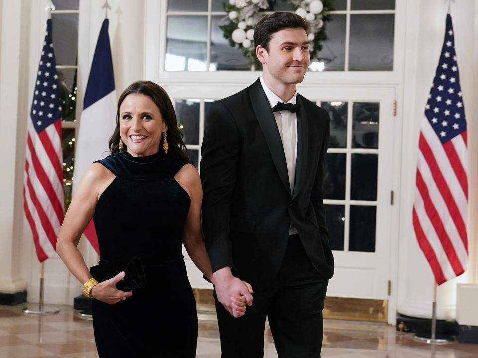 Charlie en smoking et Julia en robe noire alors qu'ils entrent dans la Maison Blanche