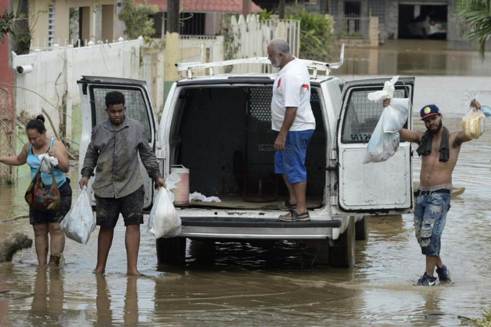 Residents with provisions in the aftermath of Hurricane Maria, in Toa Baja, Puerto Rico (AP)