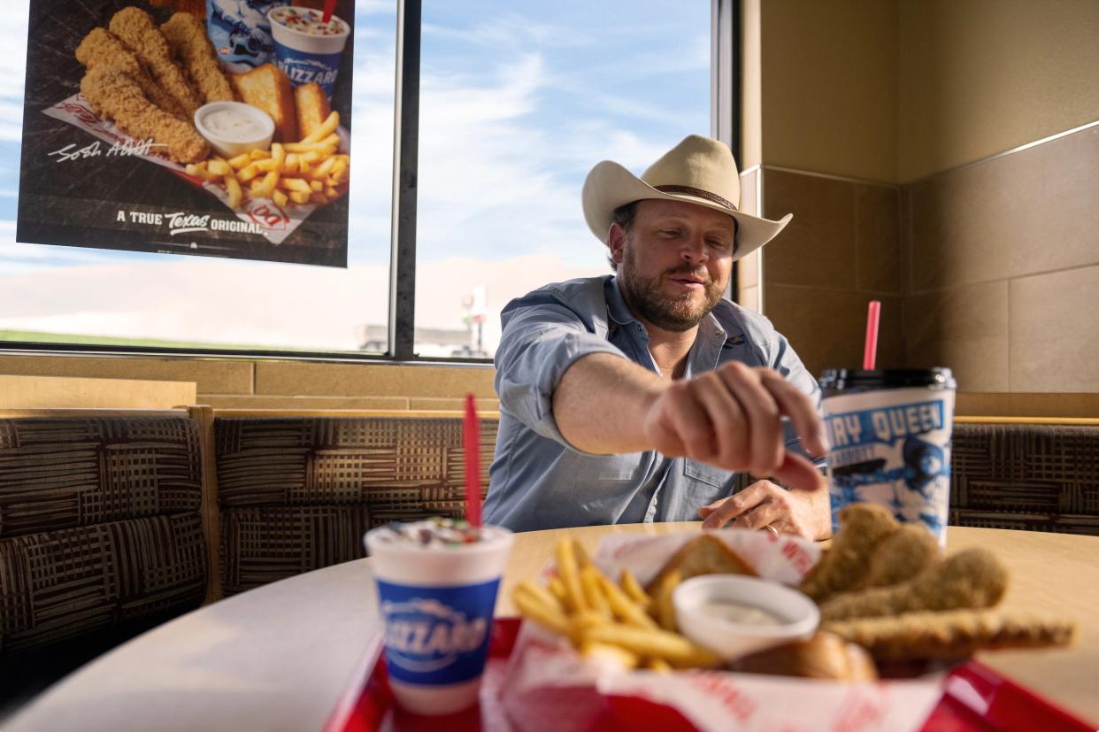 Josh Abbott reaches for a steak finger as he enjoys his favorite childhood meal at Dairy Queen.
