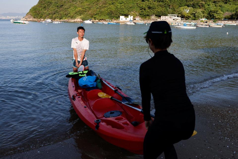 Jesse Yu and yoga teacher Zero Chan, 36, move a canoe onto the beach on Peng Chau island (All Reuters)