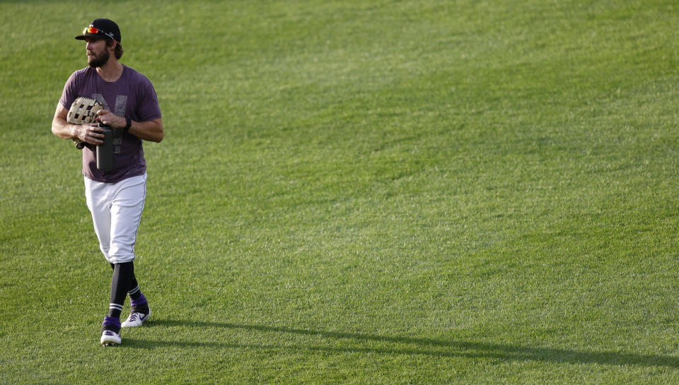 Colorado Rockies left fielder David Dahl casts a long shadow as he takes part in drills during the team's baseball practice in Coors Field, Friday, July 10, 2020, in Denver. (AP Photo/David Zalubowski)