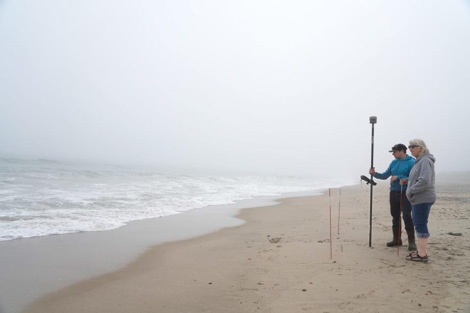 Coastal geologists Nathan Vinhateiro and Janet Freedman watch the changing water line during low tide at South Kingstown Town Beach.