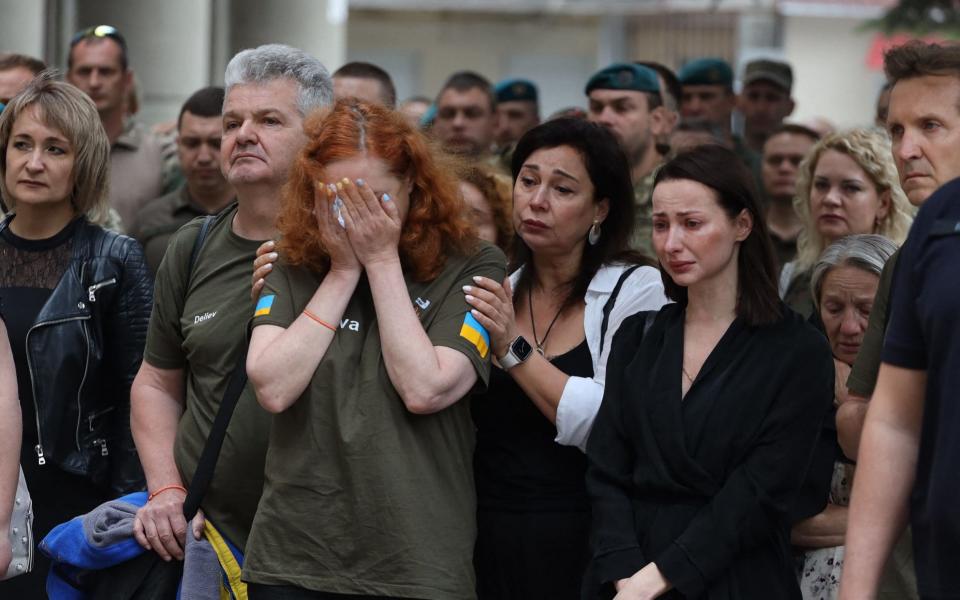 People stand in tears at the funeral ceremony of Lieutenant Colonel Sergiy Derduga, Commander of the Ukrainian 18th Marine Battalion, in Odesa. - Oleksandr Gimanov/AFP