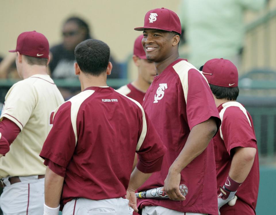 Florida State's Jameis Winston, second from right, smiles as he waits to take batting practice before an NCAA college baseball game against South Florida Tuesday, March 4, 2014, in Tampa, Fla. (AP Photo/Chris O'Meara)