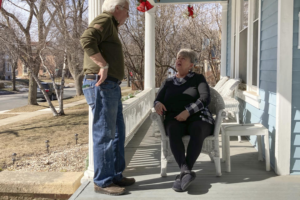 In this March 8, 2021, photo, Jaci Jageson talks with her husband Larry Lageson on the porch of their home in Mankato, Minn. The retired couple's precinct is one of several in the small, Midwestern city where heavy support for Joe Biden last year helped the Democrat carry Blue Earth County, where Republican Donald Trump won in 2016. (AP Photo/Tom Beaumont)