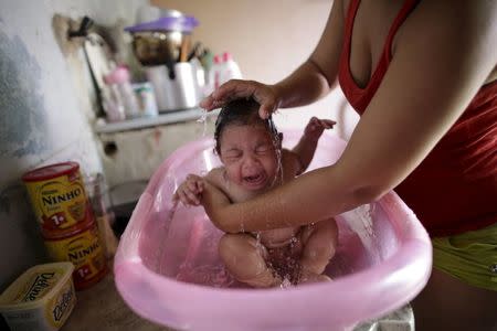 Rosana Vieira Alves bathes her 4-month-old daughter Luana Vieira, who was born with microcephaly, at their home in Olinda, Brazil, February 4, 2016. REUTERS/Ueslei Marcelino
