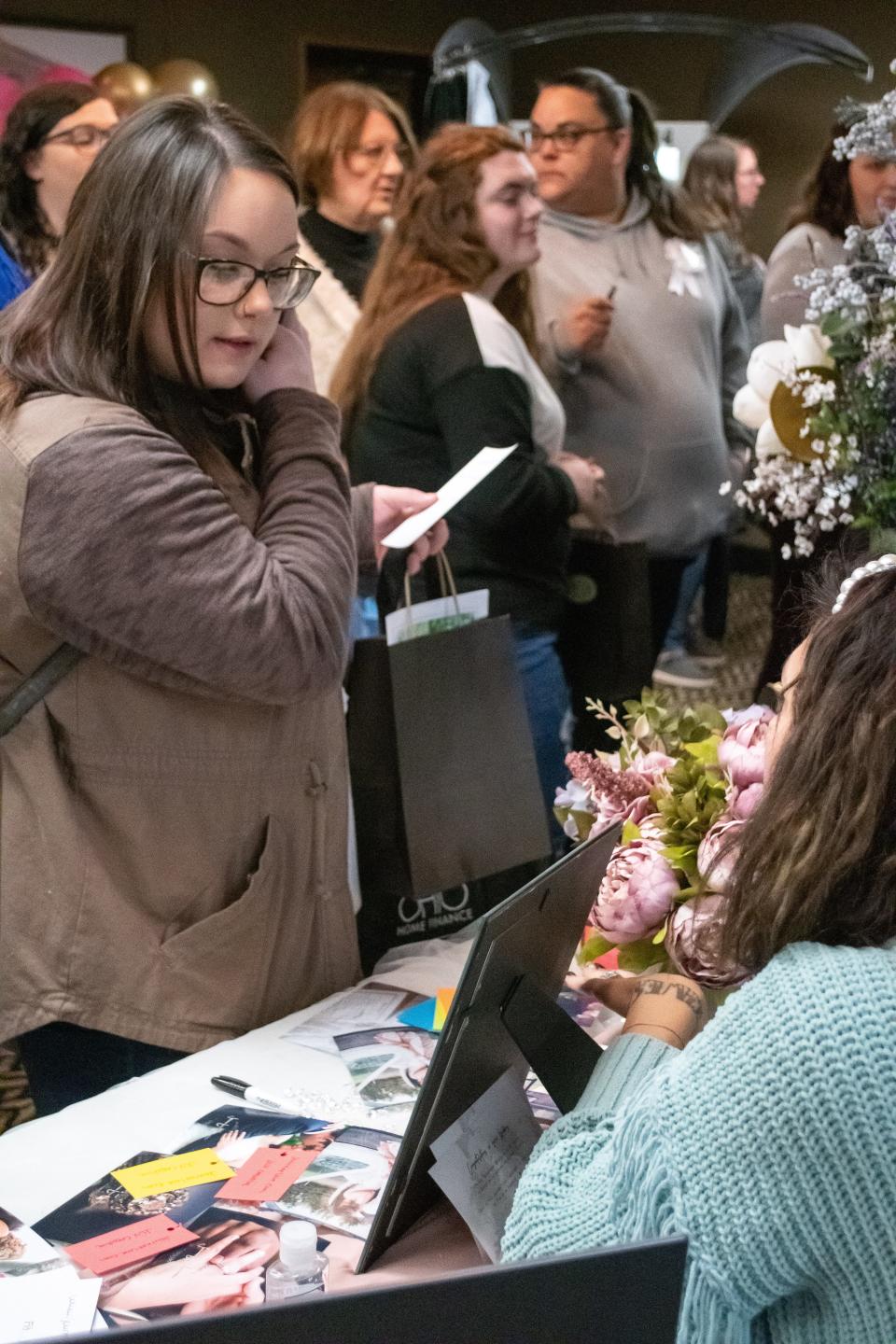 A bridal show attendee stops and speaks with JLV Creative about photography services at the 2022 Tux & Stuff Bridal Show. This years event will take place at Pritchard Laughlin Civic Center and is set to feature more than 40 area vendors.