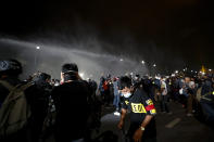 Police use water cannons to disperse pro-democracy protesters during a street march in Bangkok, Thailand Sunday, Nov. 8, 2020. The protesters continue to gather Sunday, led by their three main demands of Prime Minister Prayuth Chan-ocha's resignation, changes to a constitution that was drafted under military rule and reforms to the constitutional monarchy. (AP Photo/Sakchai Lalit)