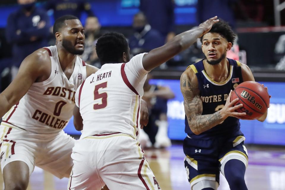 Boston College's Frederick Scott (0) and Jay Heath (5) defend against Notre Dame's Prentiss Hubb (3) during the first half of an NCAA college basketball game, Saturday, Feb. 27, 2021, in Boston. (AP Photo/Michael Dwyer)