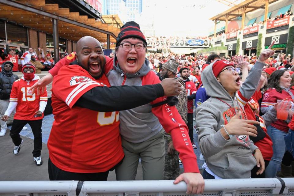 Chiefs fans from left, Jimmie Clark of East St. Louis, Andrew Kang of Kansas City and his brother, Joonyoung Yang, right, who flew in from South Korea Sunday for the Chiefs game, celebrate a touchdown at the Power & Light District during the AFC Championship Game on Sunday, Jan. 27, 2024.
