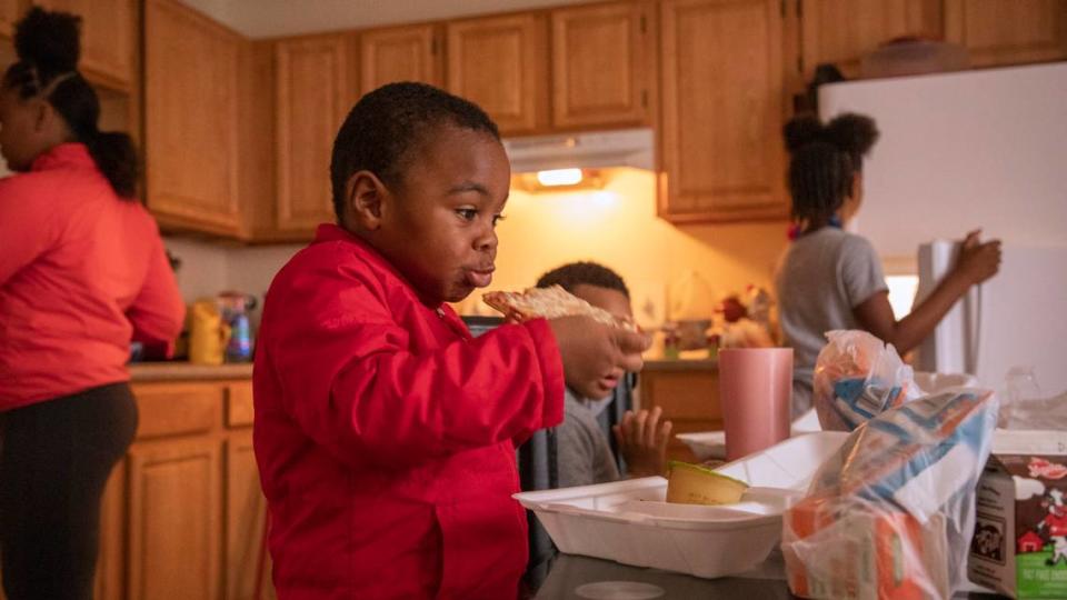 J-Sheer Williams, 3, eats a lunch of pizza, butternut squash and apple sauce at home with his siblings, on Thursday, Mar. 26, 2020, in Durham, N.C. as North Carolina public schools remain closed until May 15, 2020 in an effort to slow the spread of the coronavirus.