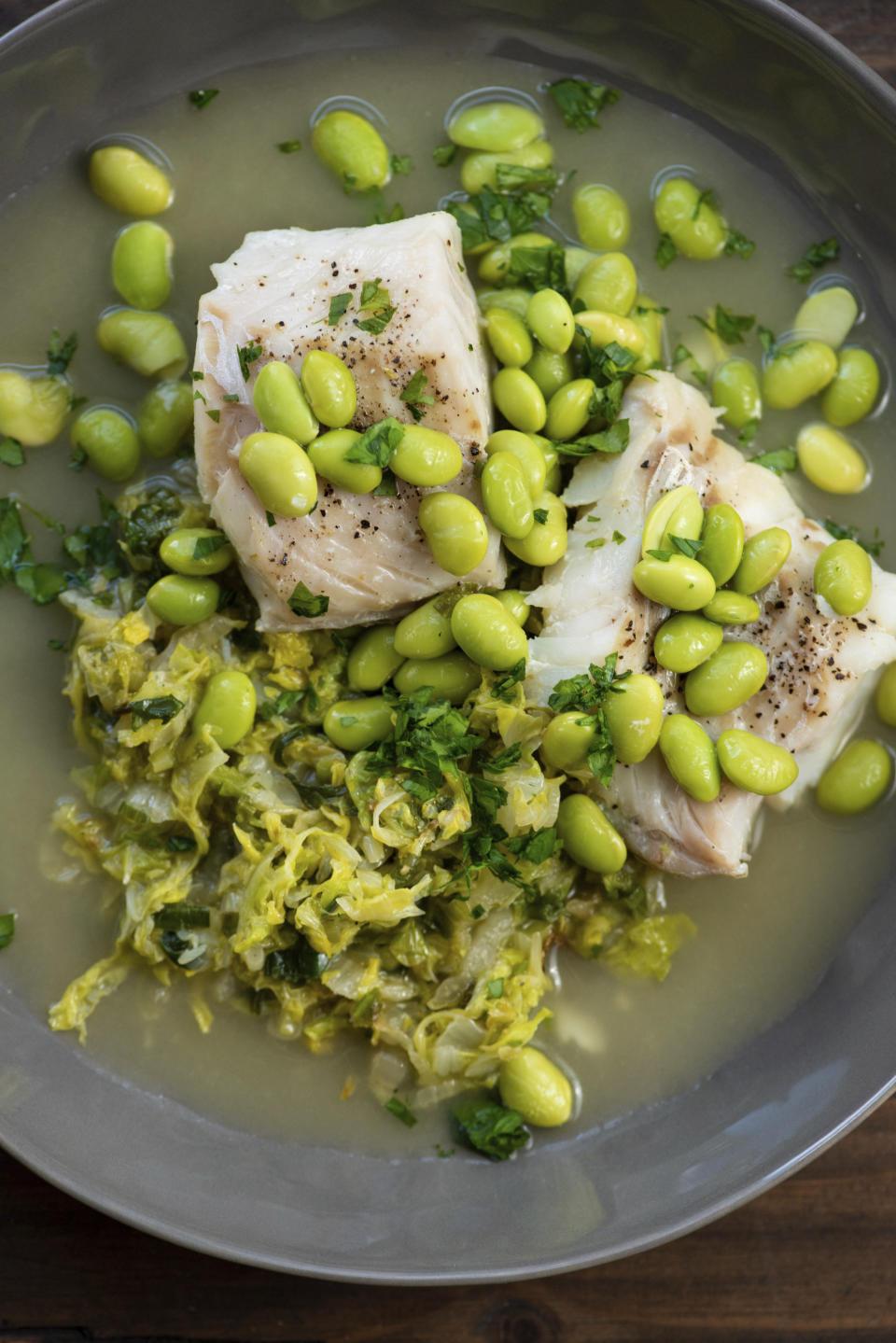 This 2018 photo provided by Katie Workman shows a dish of cod, cabbage and edamame taken in New York. Cabbage, that taken-for-granted vegetable, that sturdy, dense staple of many a poor, ancestral homeland, is finally getting respect. (Cheyenne Cohen/Katie Workman via AP)