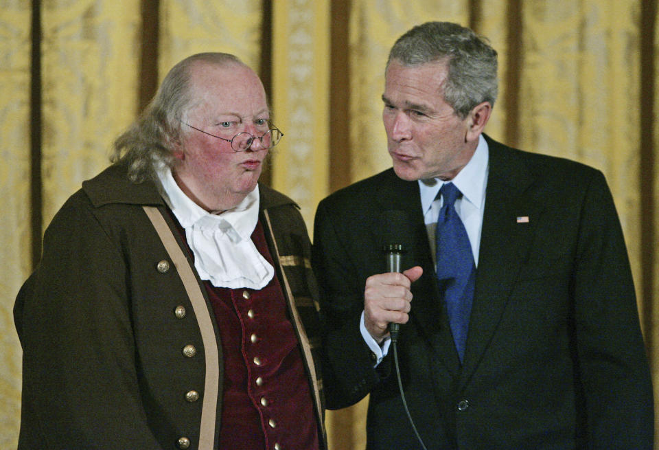 FILE – In this March 23, 2006, file photo, President George W. Bush, right, speaks after a performance by re-enactor Ralph Archbold, left, portraying Benjamin Franklin to mark the 300th anniversary of Franklin's birth on Jan. 17, 1706, in the East Room of the White House in Washington. Archbold, who portrayed Franklin in Philadelphia for more than 40 years, died Saturday, March 25, 2017, at age 75, according to the Alleva Funeral Home in Paoli, Pa. (AP Photo/Manuel Balce Ceneta, File)