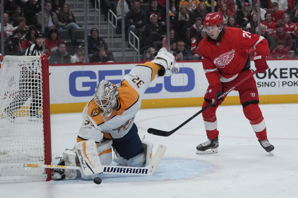 Nashville Predators goaltender Kevin Lankinen (32) stops a shot as Detroit Red Wings center Oskar Sundqvist (70) watches for the rebound in the second period of an NHL hockey game Wednesday, Nov. 23, 2022, in Detroit. (AP Photo/Paul Sancya)